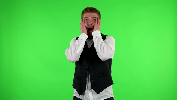 Man Carefully Examines Something Then Fearfully Covers His Face with His Hands. Green Screen
