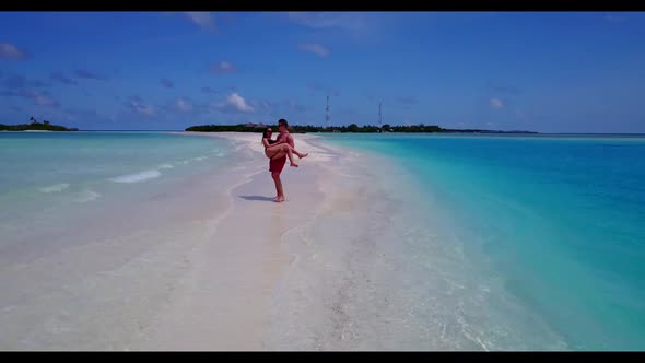 Man and woman relax on tropical coast beach voyage by blue green ocean with white sandy background o