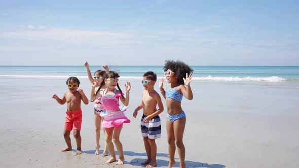 4K Group of Diversity children playing on tropical beach together on summer vacation at the sea