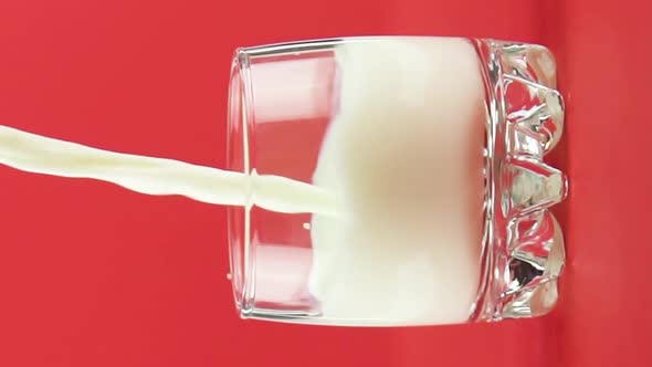 Vertical Video Slow Motion Closeup Shot of Cold Diary Milk Cold Beverage Drink Pooring Into Small
