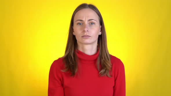 Woman Switches Channels with Remote Control Watches TV on a Yellow Background