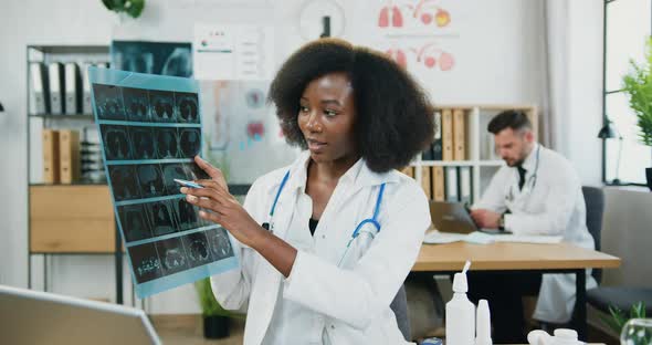 Black-Skinned Female Medical Worker Explaining Results of X-ray Scan on Camera