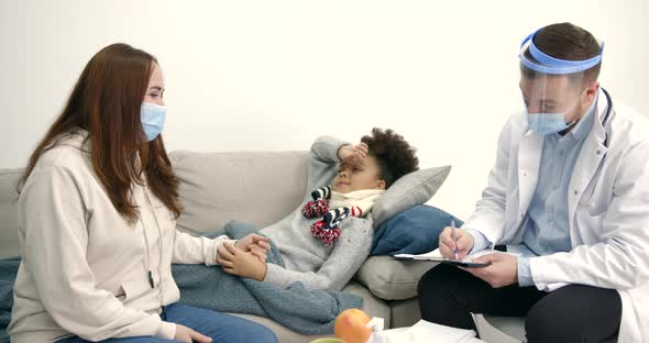 Pediatrician and Mother Near Little Black Girl at Home