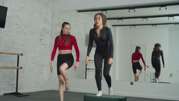 Fitness Instructor Teaching Woman Step Up Exercise