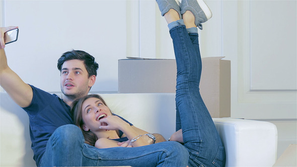 A Girl And A Guy Moving And Smiling At The Phone