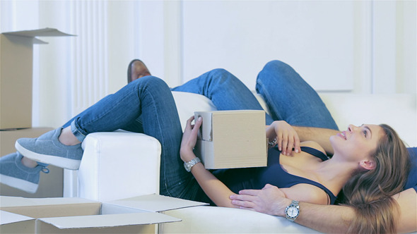 Couple In Love Lying Among The Boxes