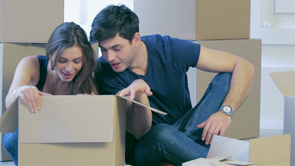 Couple In Love Pulls Things Out Of Boxes