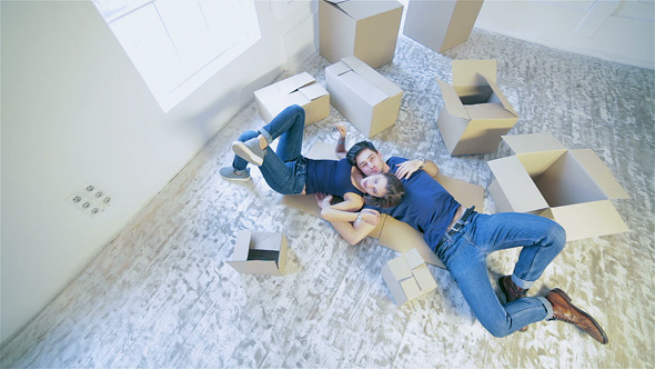 Couple Lying On The Floor Among The Boxes