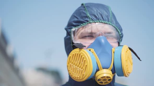 Close-up of Caucasian Man in Protective Chemical Suit and Respirator. Portrait of Worker Standing