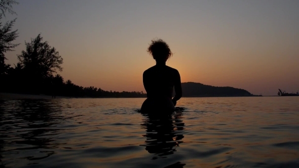 Woman Silhouette Swimming In Sea Against Sunset