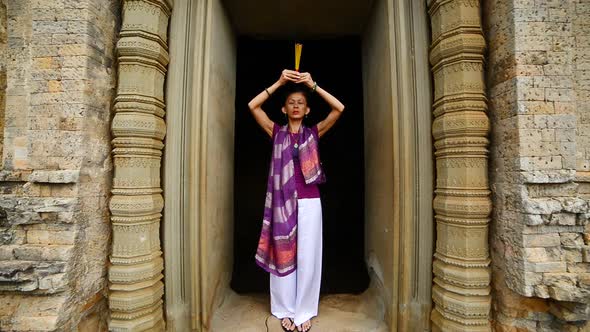 Female Buddhist Praying With Incense In Temple Doorway -   Angkor Wat Temple Cambodia 1 alt