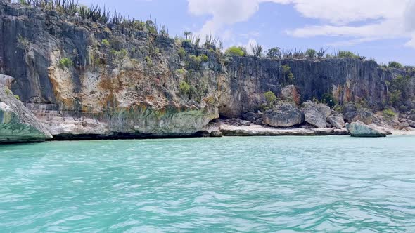 Pov shot of boat showing CABO ROJO PEDERNALES cliffs and splashing water during sunny day