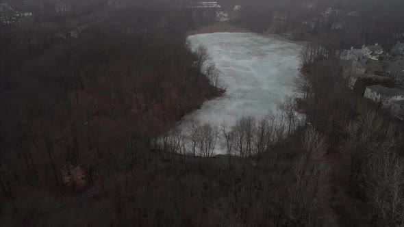 Flying Over a Frozen Lake Surrounded by Trees in Mahopac NY