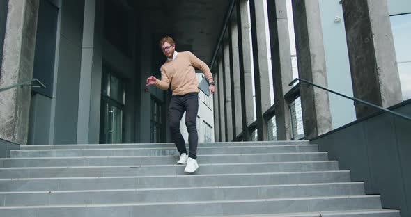 Happy Young Man Actively Dancing While Walking Down the stairs.