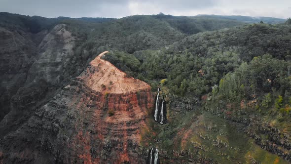 Aerial video showing a wooded mountain and Waipoo waterfalls in Waimea Canyon, Kauai, Hawaii