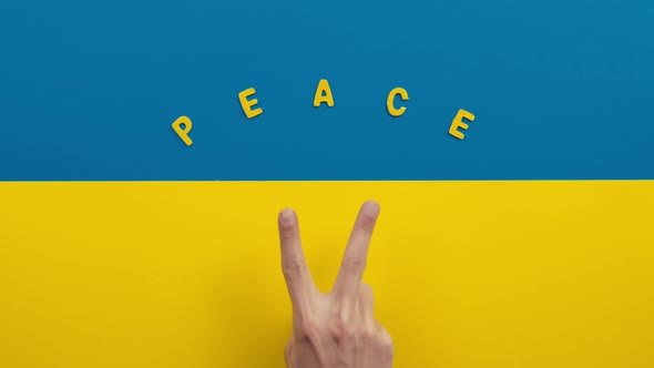 Victory and Peace with Hand Making Symbol on the Flag of Ukraine