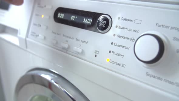 Man Putting Laundry Into Washing Machine 1