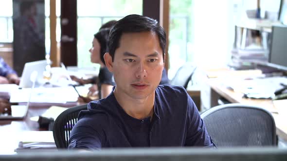 Architect Working At Desk With Meeting In Background 2 alt