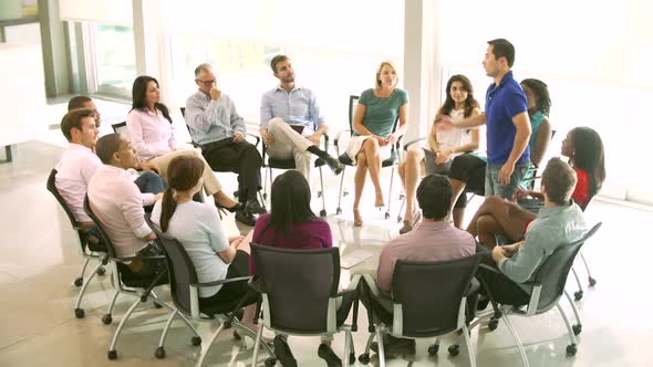 Support Group Meeting With People Seated In Circle Of Chairs