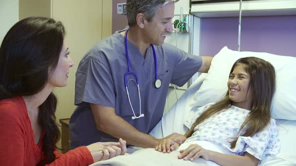 Mother And Daughter Talking With Male Nurse In Hospital Room alt