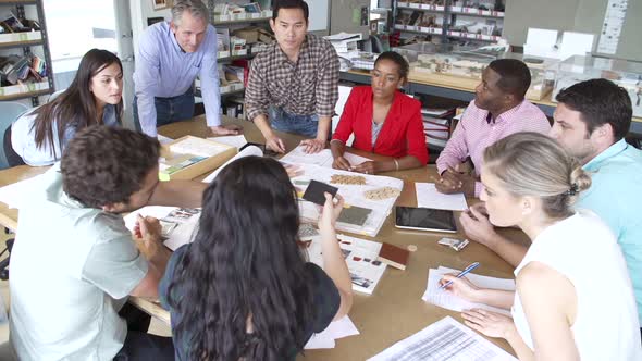 Architects Sitting Meeting Around Table To Discuss Materials