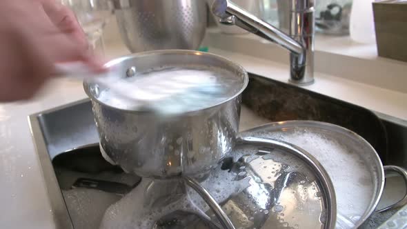 Man Washing Pans In Sink