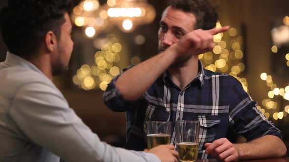 Two Male Friends Enjoying Evening Drinks In Bar 2