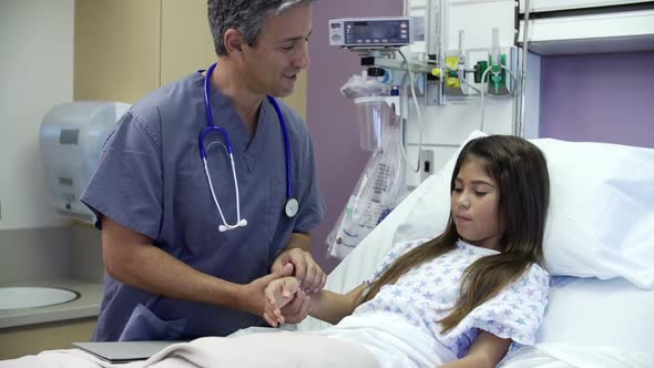 Young Girl Talking To Male Nurse In Hospital Room 1