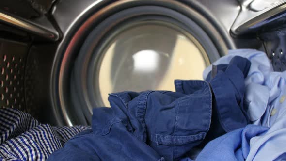 Man Putting Laundry Into Washing Machine 2