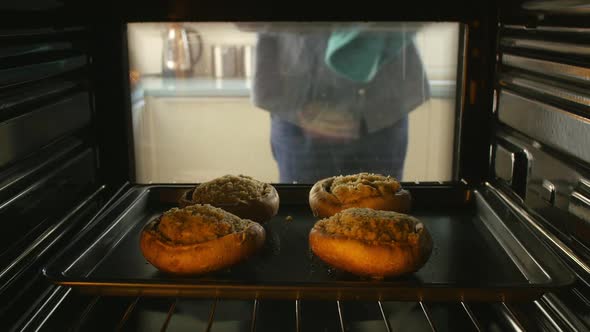 Man Putting Stuffed Mushrooms Into Oven To Cook