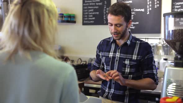 Man Serving Female Customer In Coffee Shop