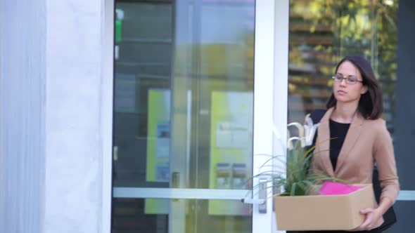 Redundant Businesswoman Leaving Office With Box 1