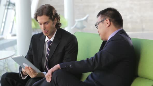 Businessmen On Sofa And Using Digital Tablet alt