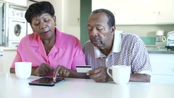 Senior Couple Booking Vacation Online Using Digital Tablet 1 alt