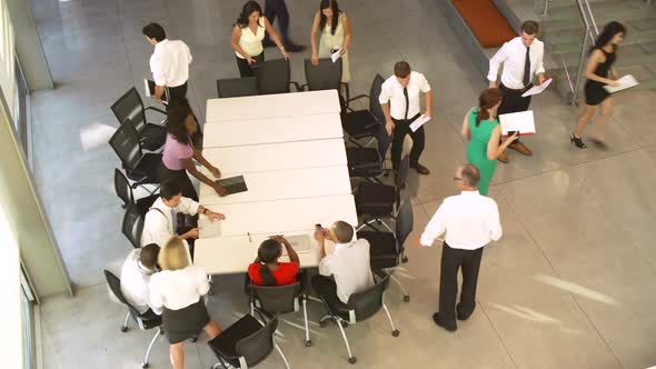 Businesspeople Leaving At The End Of Meeting Around Table