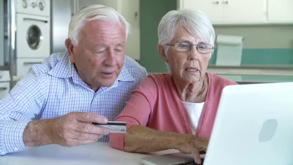 Senior Couple Booking Vacation Online Using Digital Tablet 2