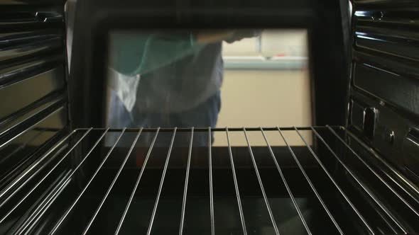 Man Taking Cooked Tray Of Salmon Fillets Out Of The Oven