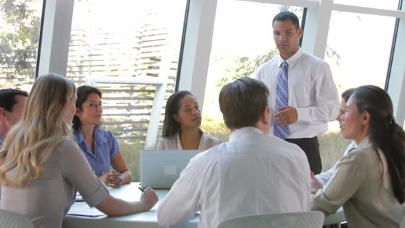 Businesspeople Seated Around Table Having Meeting 3