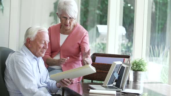 Senior Couple Looking At Picture In Frame And Photo Album 1