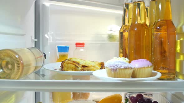 Woman Taking Bottle Of White Wine From The Fridge alt