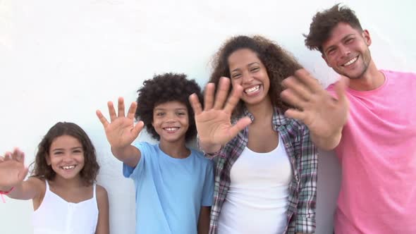 Family Standing Against Wall And Waving 1