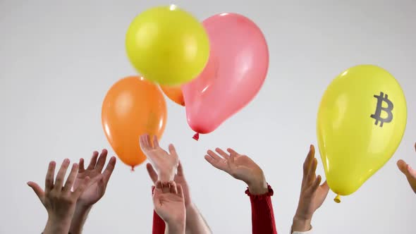 Human Hands Throw Up Balloons with Symbols of Cryptocurrency