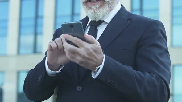 Man in Suit Showing Yes Gesture, Happy About Winning Game on Phone, Leisure Time