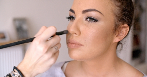 Makeup Artist Applying Blush To a Pretty Woman