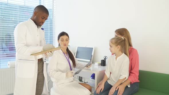 Doctor and Assistant Showing Back Xray to Sick Patients