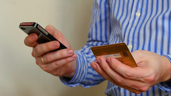 Businessman Paying With Credit Card On Phone