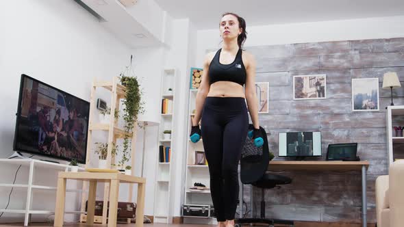 Young Woman Holding Dumbbells While Doing Lunge Workout