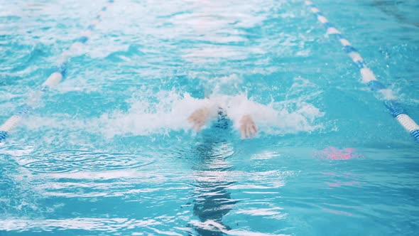 Front View of a Man Crossing the Swimming Pool in Slow Motion