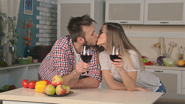 Young Loving Couple Drinking Wine in the Kitchen