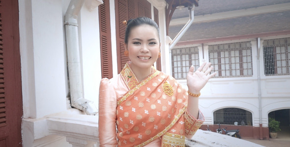 Girl In Laos Traditional Clothes Waving Goodbye